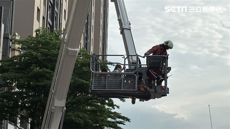 消防隊員以雲梯車將受困住戶救下。（圖／記者羅欣怡攝影）