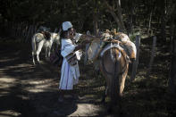 Sebastian, an Arhuaco Indigenous man, ties cargo to his mules in Nabusimake on the Sierra Nevada de Santa Marta, Colombia, Monday, Jan. 16, 2023. To be allowed to climb the Sierra Nevada into Arhuaco lands it is necessary to obtain a permit from them and to submit to their laws. (AP Photo/Ivan Valencia)