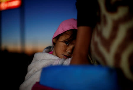 A migrant girl, part of a caravan of thousands traveling from Central America to the United States, prepares to get on a bus bound for Mexicali at a makeshift camp in Navojoa, Mexico November 17, 2018. REUTERS/Kim Kyung-Hoon