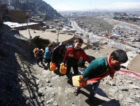 Afghan boys carry water as they climb a hill in Kabul, Afghanistan February 20, 2017. Picture taken February 20, 2017. REUTERS/Omar Sobhani