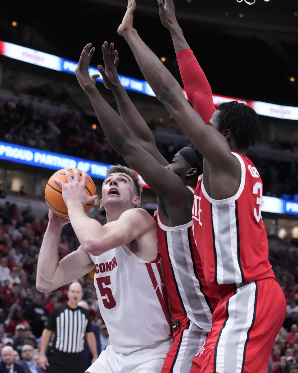 Wisconsin's Tyler Wahl eyes the basket as Ohio State's Isaac Likekele and Felix Okpara (34) defend during the second half of an NCAA college basketball game at the Big Ten men's tournament, Wednesday, March 8, 2023, in Chicago. Ohio State won 65-57. (AP Photo/Charles Rex Arbogast)