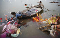 <p>Indian boys pull an idol of Hindu goddess Durga to shore to clean up the temporary water body beside the Ganges river, after immersion of Durga idols by Hindu devotees in Allahabad, India, Saturday, Sept. 30, 2017. (Photo: Rajesh Kumar Singh/AP) </p>