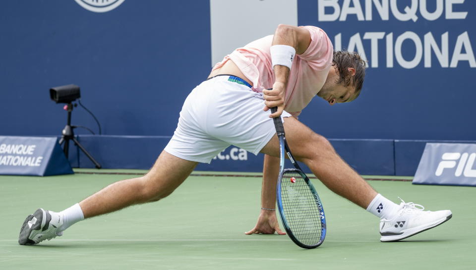 Alexis Galarneau of Canada slips during his match against Grigor Dimitrov of Belarus during first round play at the National Bank Open tennis tournament Tuesday Aug. 9, 2022, in Montreal. (Paul Chiasson/The Canadian Press via AP)