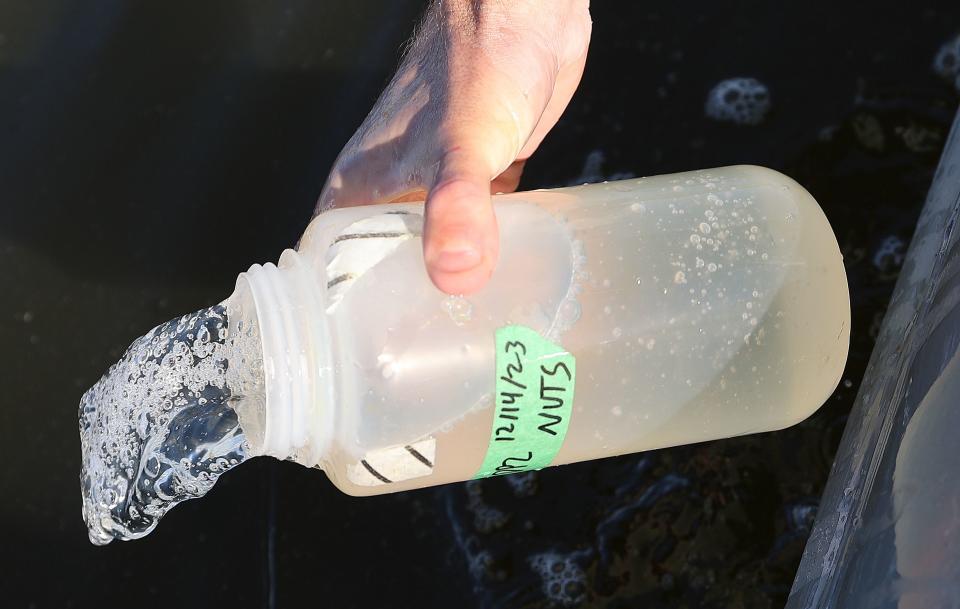 Quinn Montgomery, Alianza consultant biologist, rinses out a bottle before collecting a water sample to look for nutrient pollution, algae and bacteria in the Salton Sea, Calif., on Thursday, Dec. 14, 2023. | Kristin Murphy, Deseret News