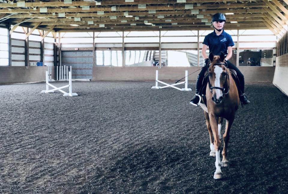 Adelyn Pitchforth, 13, of Kennebunk, Maine, takes a rising lesson in one of the two indoor arenas at Carlisle Academy in Lyman, Maine, on July 13, 2023.