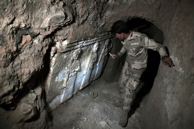 A member of the Iraqi troops stands next to archeological findings inside an underground tunnel in east Mosul, northern Iraq on March 6, 2017