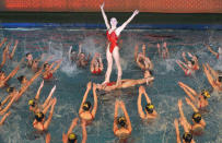 North Koreans perform a synchronized swimming program titled "We protect North Korea's new leader Kim Jong-un at the risk of our own life" during a festival to mark the birth anniversary of the North's late leader Kim Jong-Il in Pyongyang in this photo taken by Kyodo February 15, 2012. Kim's 70th birthday falls on February 16, 2012. Mandatory Credit REUTERS/Kyodo (JAPAN - Tags: POLITICS ANNIVERSARY) JAPAN OUT. NO COMMERCIAL OR EDITORIAL SALES IN JAPAN. FOR EDITORIAL USE ONLY. NOT FOR SALE FOR MARKETING OR ADVERTISING CAMPAIGNS. THIS IMAGE HAS BEEN SUPPLIED BY A THIRD PARTY. IT IS DISTRIBUTED, EXACTLY AS RECEIVED BY REUTERS, AS A SERVICE TO CLIENTS. MANDATORY CREDIT