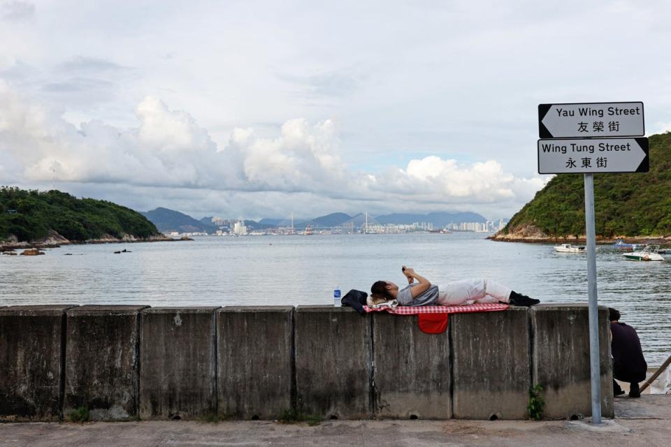 A woman relaxes near the seashore (Reuters)