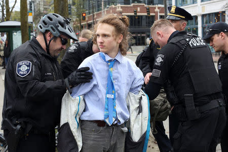 A protestor, who attempted to disrupt the official rally program, is detained by police officers during the March For Science in Seattle, Washington, U.S. April 22, 2017. REUTERS/David Ryder