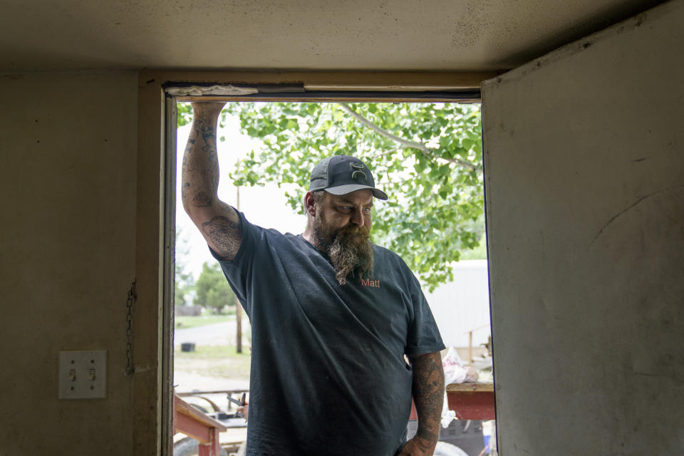 Matt Holmes looks at his damaged home while packing up belongings as the family is forced to leave after severe flooding in Fromberg, Mont., Friday, June 17, 2022. (AP Photo/David Goldman)