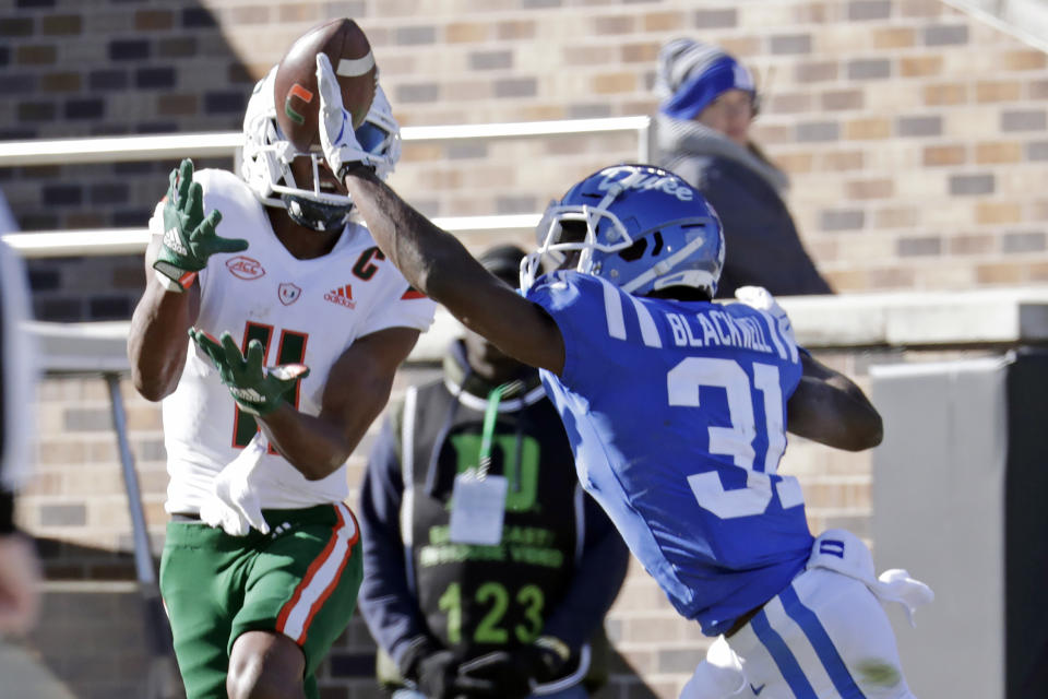 Miami wide receiver Charleston Rambo (11) hauls in a touchdown pass against Duke cornerback Josh Blackwell (31) during the first half of an NCAA college football game Saturday, Nov. 27, 2021, in Durham, N.C. (AP Photo/Chris Seward)