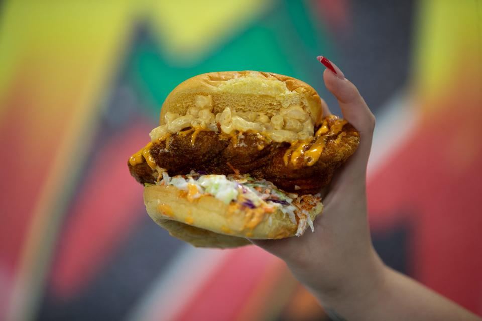 The Slider, with an add-on of macaroni and cheese and boom boom sauce, is held by employee Selina López at Hot Chicken Run Wednesday, Jan. 3, 2024.