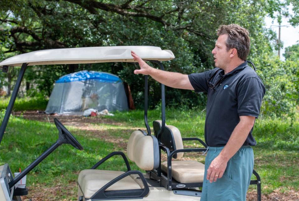 Steve Brown, owner of global parts distributor Spaires Inc., points out several homeless camps set up just outside his fence line including this tent that just popped up three days earlier in Brent on Thursday, June 1, 2023.