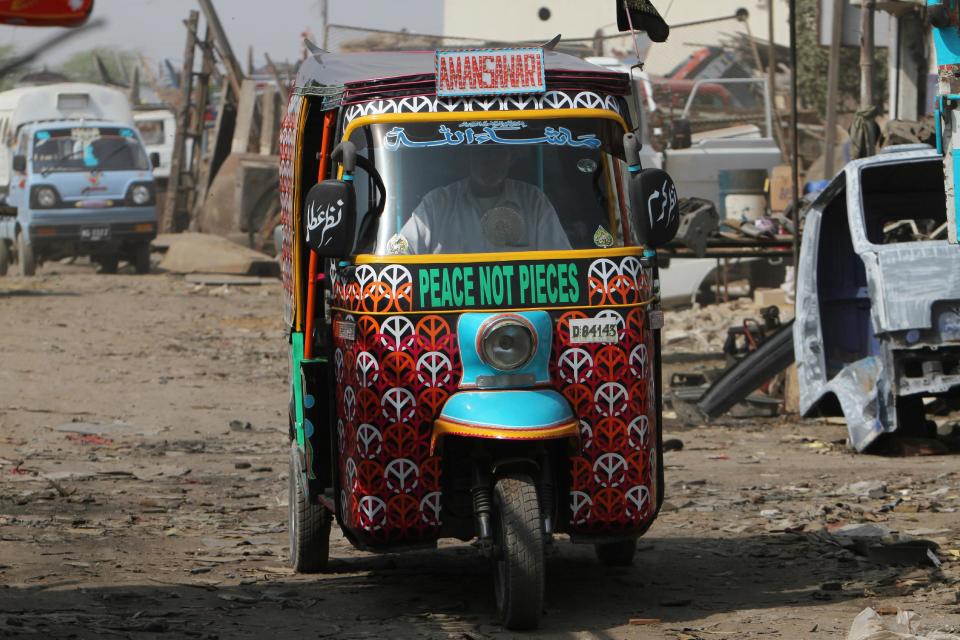 In this Saturday, Feb. 2, 2013 photo, a Pakistani rickshaw driver makes his way through slums of Karachi, Pakistan. Pakistani youth leader Syed Ali Abbas Zaidi has an innovative plan to counter the relentless message of violence spewed forth by radical Islamic groups in the country and is stealing a trick from their playbook to do it. His weapon: the three-wheeled motorized rickshaws that buzz along Pakistan’s streets carrying paying customers. (AP Photo/Fareed Khan)