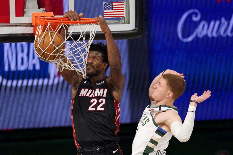 Miami Heat's Jimmy Butler (22) dunks the ball after getting past Milwaukee Bucks' Donte DiVincenzo (0) during the second half of an NBA basketball conference semifinal playoff game, Monday, Aug. 31, 2020, in Lake Buena Vista, Fla. (AP Photo/Mark J. Terrill)