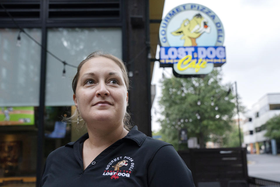 Sarah White, area manager of Lost Dog Cafe, poses for a portrait outside the cafe in Fairfax, Va., on Friday, Aug. 27, 2021. Lost Dog is one of a growing number of companies that, in a desperation for hired hands, is loosening restrictions on everything from age to level of experience.(AP Photo/Jacquelyn Martin)