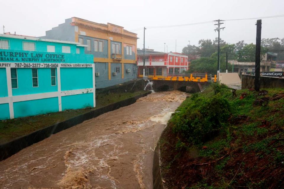 Un río crecido por las lluvias provocadas por el huracán Fiona atraviesa Cayey, Puerto Rico, el domingo 18 de septiembre de 2022.