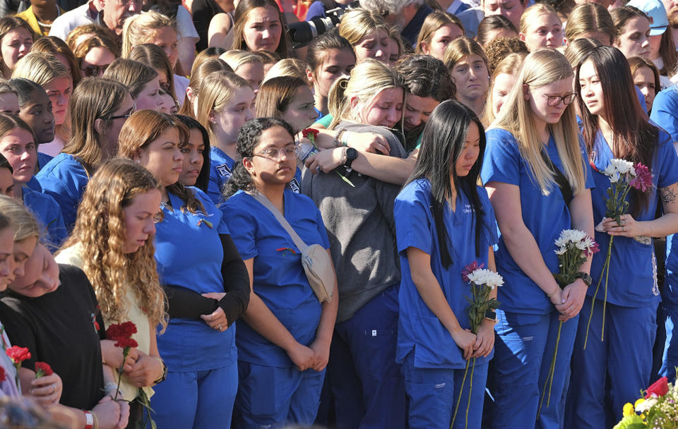 Augusta University students, in blue, and University of Georgia students gather at the Tate Plaza on the UGA campus in Athens, Ga., Monday, Feb. 26, 2024, to pay tribute to Laken Riley, a nursing student at Augusta University's Athens campus who was found dead Thursday, Feb. 22, after a roommate reported she didn't return from a morning run in a wooded area of the UGA campus near its intramural fields. UGA students also gathered to pay tribute to a student who committed suicide last week. (Nell Carroll/Atlanta Journal-Constitution via AP)