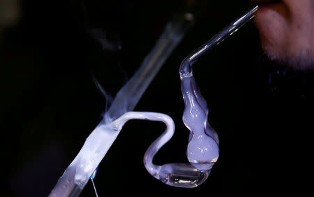 A drug addict uses a glass water pipe to smoke shabu, or methamphetamine, at an undisclosed drug den in Manila, Philippines June 20, 2016. REUTERS/Staff/File Photo