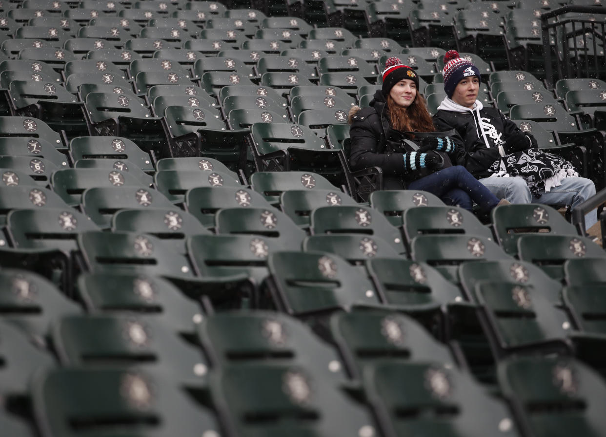 Two fans sit in the stands before a baseball game between the Chicago White Sox and the Tampa Bay Rays in Chicago, Monday, April 9, 2018. (AP Photo/Jeff Haynes)