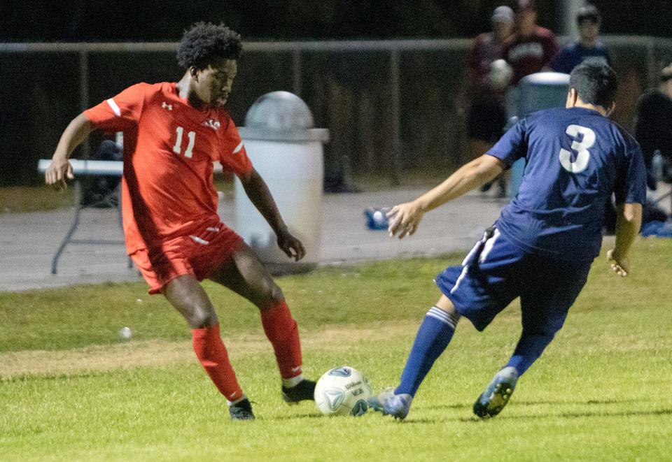 All Saints forward Sam St. Germain maneuvers around a Tampa Univeral defender on Thursday night in the championship match of the Class 2A, District 7 boys soccer tournament at Sants Fe Catholic.