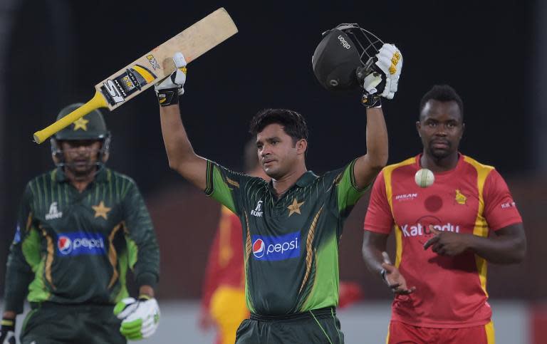 Pakistan's captain Azhar Ali (C) celebrates after scoring a century as teammate Haris Sohail (L) and Zimbabwe bowler Brian Vitori (R) look on during the second One Day International (ODI) cricket match in Lahore on May 29, 2015