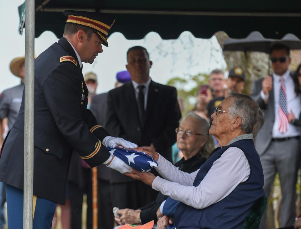 U.S Army Major Stiles (left) presents the folded flag for Robert Lee Hurst to his nephew Ernest O’Berry, during the graveside memorial for R. L. Hurst at Winter Beach Cemetery on Saturday, Feb. 17, 2024, in Vero Beach.
