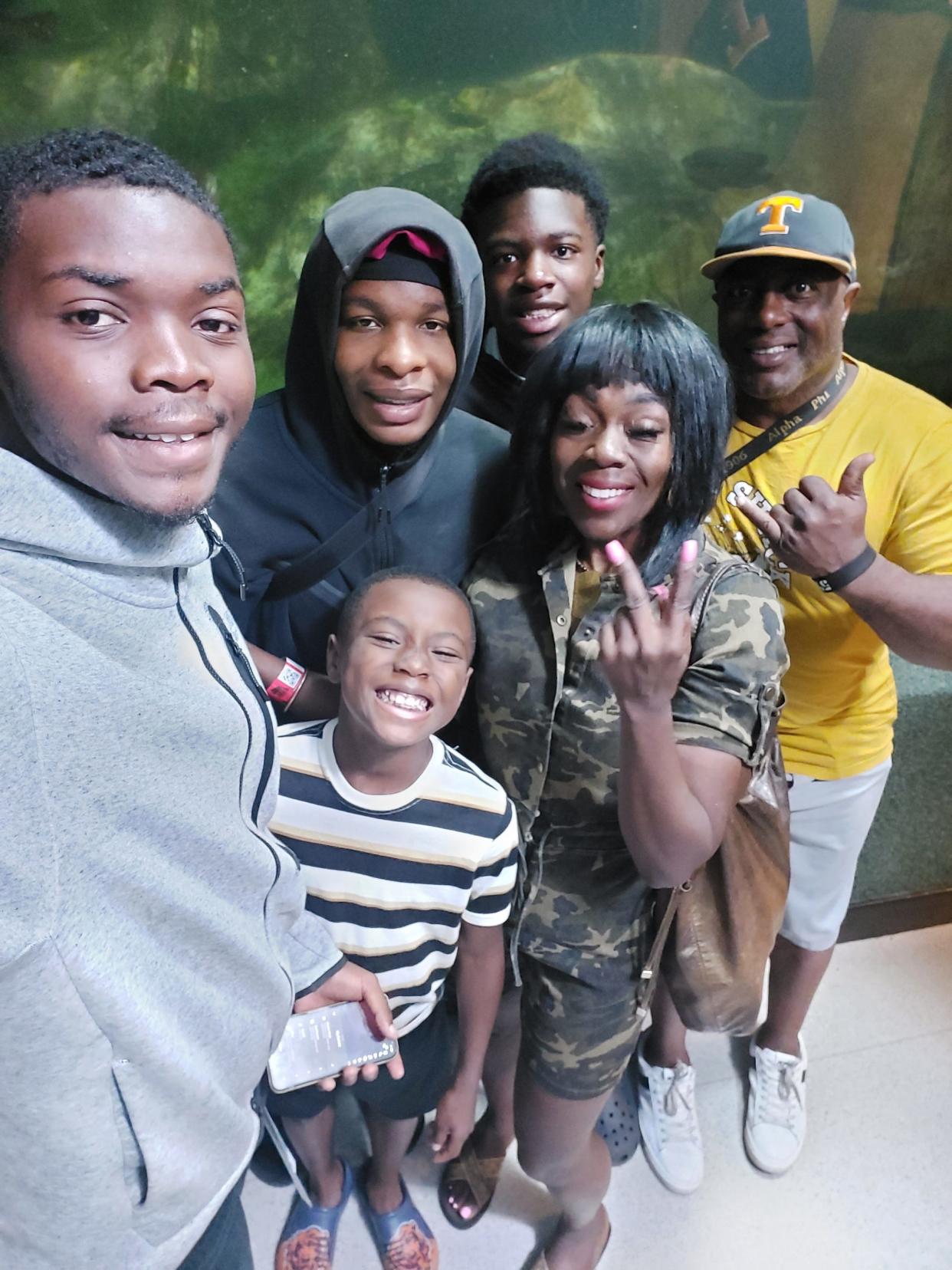 Taye Green, at center with hoodie pulled up, stands for photo with family members in early July at the Newport Aquarium in Kentucky. Green was shot and killed Friday at a pool party at an apartment complex on Columbus' Northeast Side.