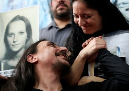 Javier Matias Darroux Mijalchuk, son of Elena Mijalchuk and Juan Manuel Darroux, who disappeared during Argentina's former 1976-1983 dictatorship, is comforted by his wife during a news conference in Buenos Aires
