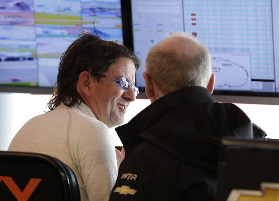 Car owner and driver Wayne Taylor, left, talks with a crew member in his pit stall during the IMSA Series Rolex 24 hour auto race at Daytona International Speedway in Daytona Beach, Fla., Sunday, Jan. 26, 2014.(AP Photo/John Raoux)