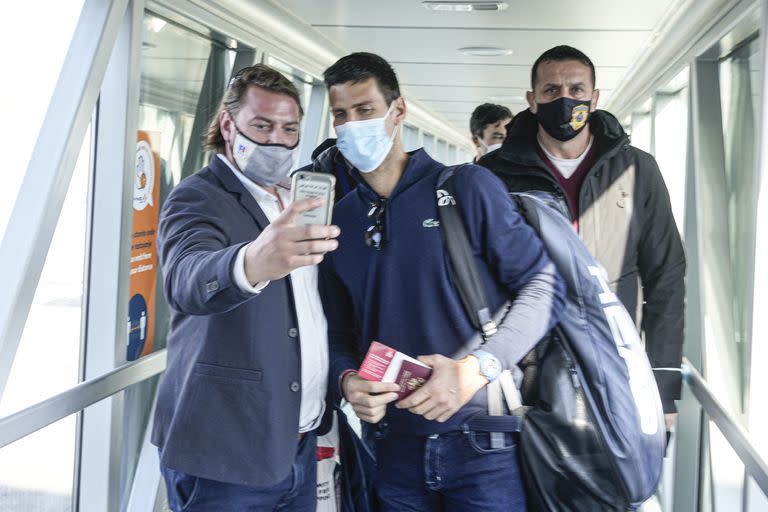 Un hombre se toma una foto con Djokovic en la llegada del tenista a Belgrado, luego de ser deportado de Australia.