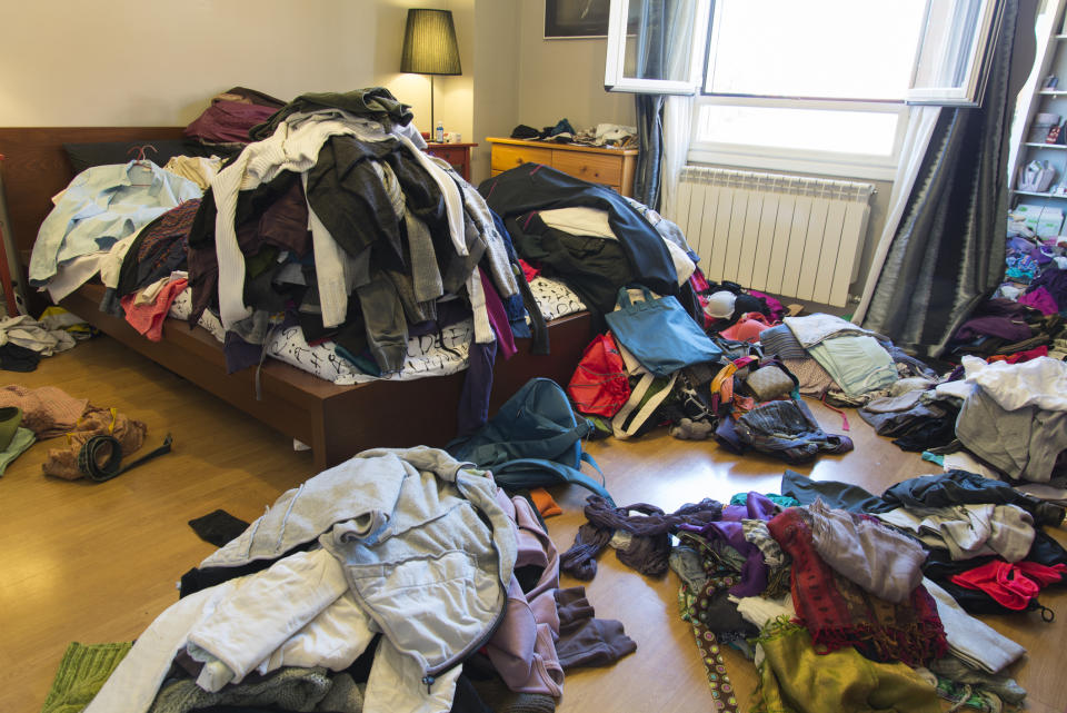 Piles of dirty laundry all over someone's bedroom