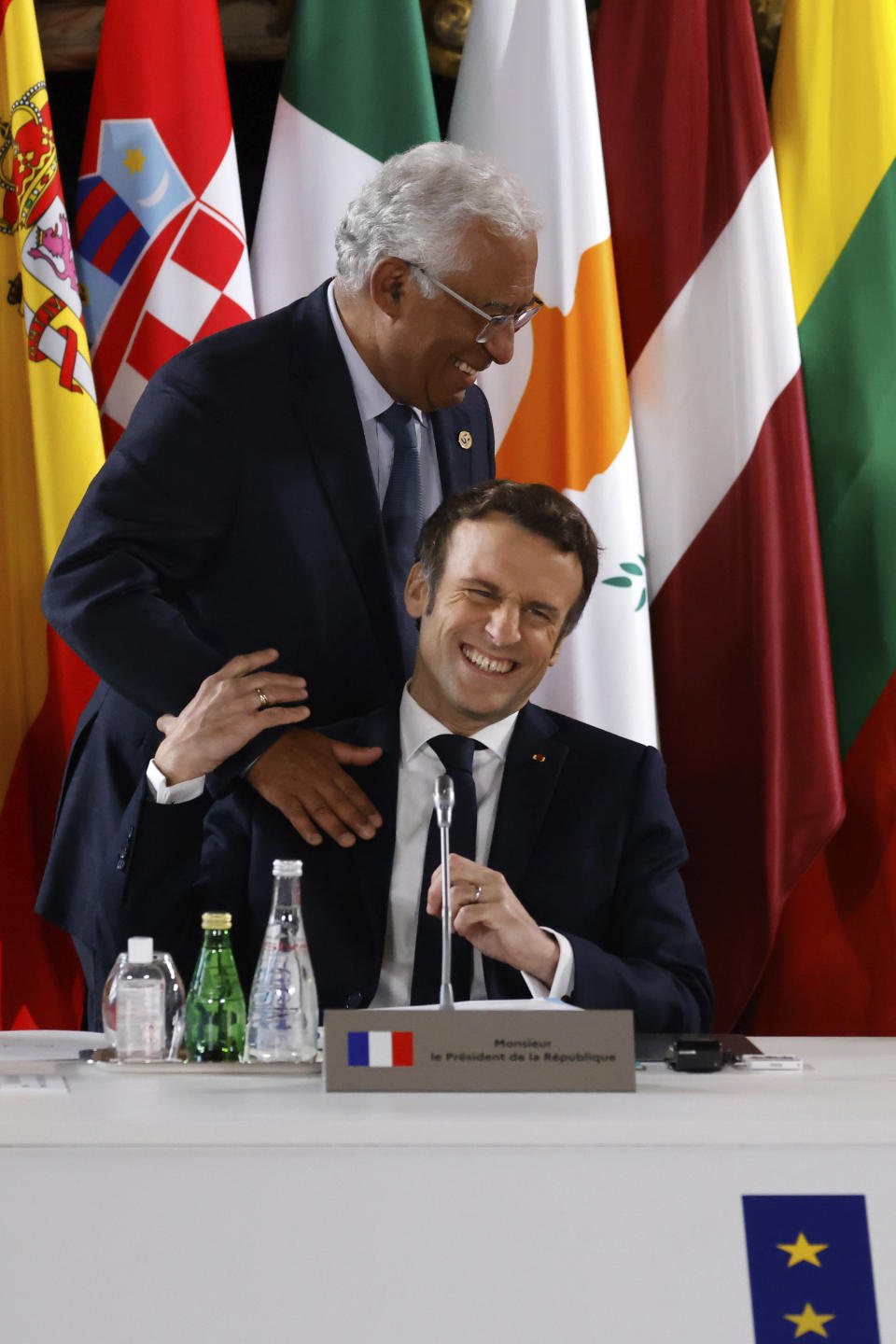 French President Emmanuel Macron share a laugh with Portugal's Prime Minister Antonio Costa, top, during a EU summit at the Palace of Versailles, west of Paris, Thursday, March 10, 2022. European Union leaders have gathered in Versailles for a two-day summit focusing on the war in Ukraine. Their nations have been fully united in backing Ukraine's resistance with unprecedented economic sanctions, but divisions have started to surface on how fast the bloc could move in integrating Ukraine and severing energy ties with Moscow. (Ludovic Marin, Pool via AP)