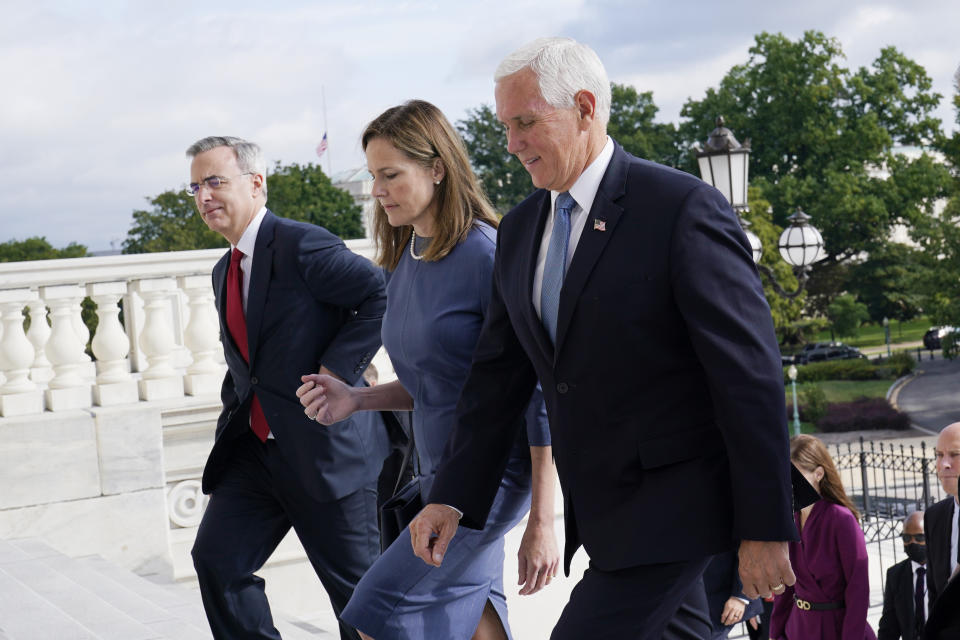 Judge Amy Coney Barrett, President Donald Trump's nominee for the U.S. Supreme Court, is escorted to the Senate by Vice President Mike Pence, right, where she will begin a series of meetings to prepare for her confirmation hearing, at the Capitol in Washington, Tuesday, Sept. 29, 2020. White House Counsel Pat Cipollone, left. (AP Photo/Susan Walsh, POOL)