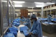 Workers check surgical gowns at a production facility in the outskirts of Ahmedabad.