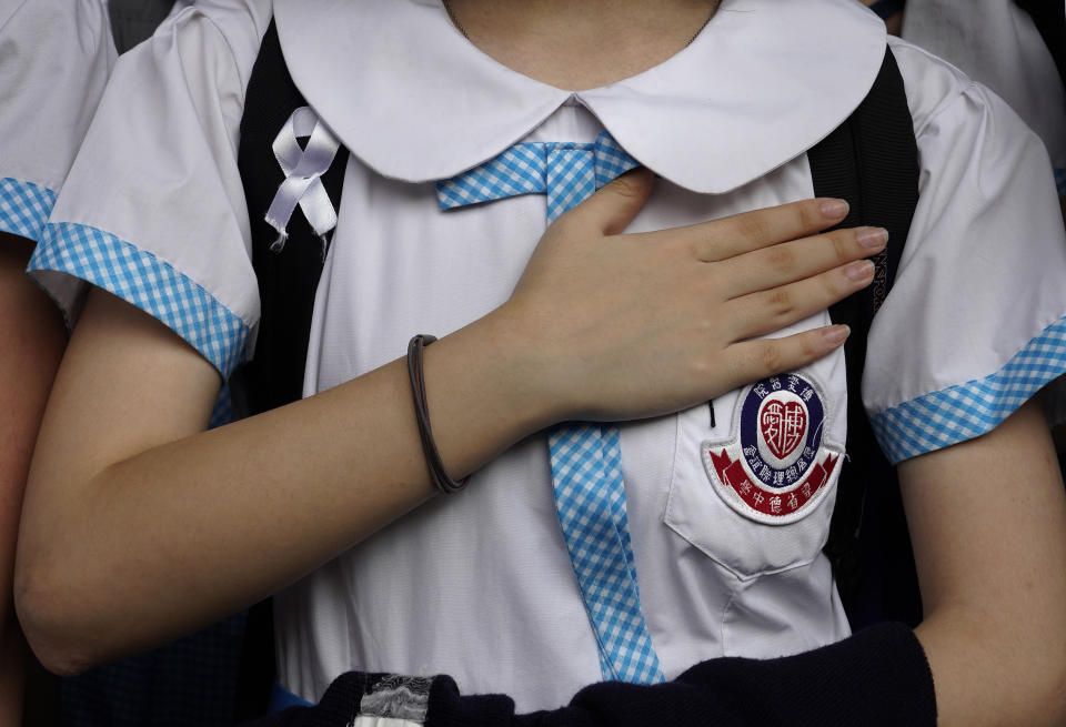 A student out her hand on the chest during a strike in Hong Kong, Wednesday, Oct. 2, 2019. Hundreds of students at a Hong Kong college have staged a strike to condemn police shooting of a teenager during widespread violence in the semi-autonomous Chinese territory at pre-democracy protests that marred China's National Day. (AP Photo/Vincent Yu)