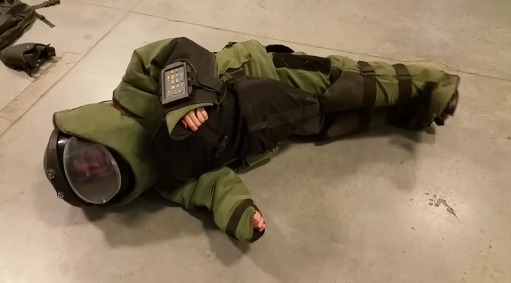 A bomb squad member put his fiancée in one of his work suits and struggled to contain his laughter when she couldn’t get up. Photo from YouTube.