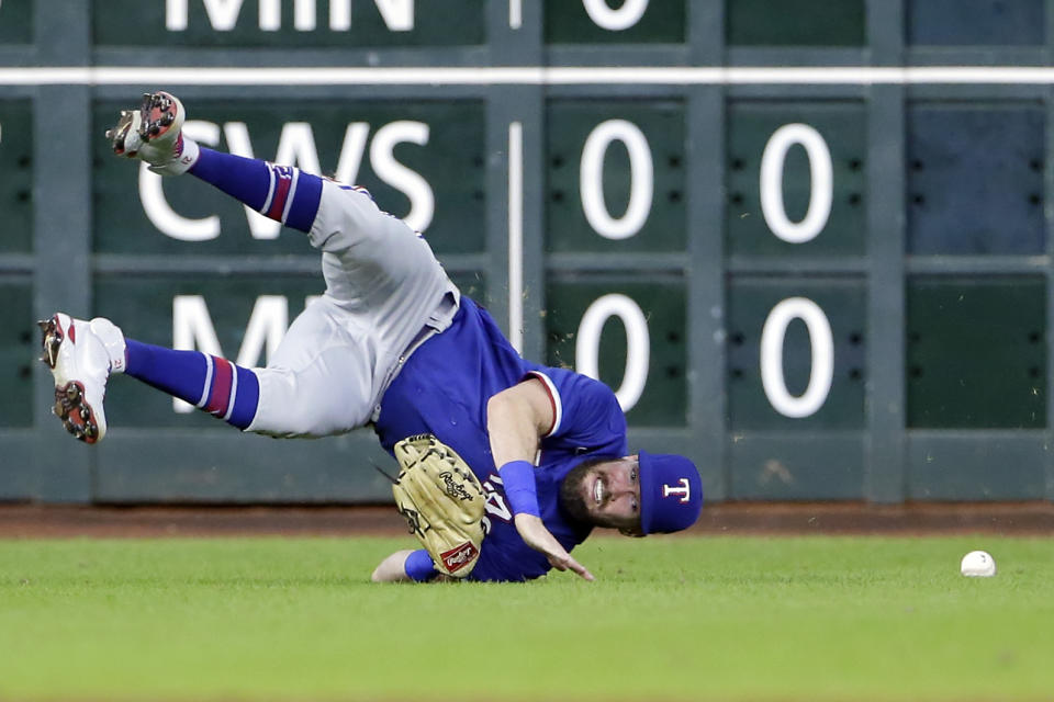 Texas Rangers left fielder David Dahl tumbles on a diving catch-attempt on a hit by Houston Astros' Michael Brantley during the third inning of a baseball game Friday, July 23, 2021, in Houston. (AP Photo/Michael Wyke)