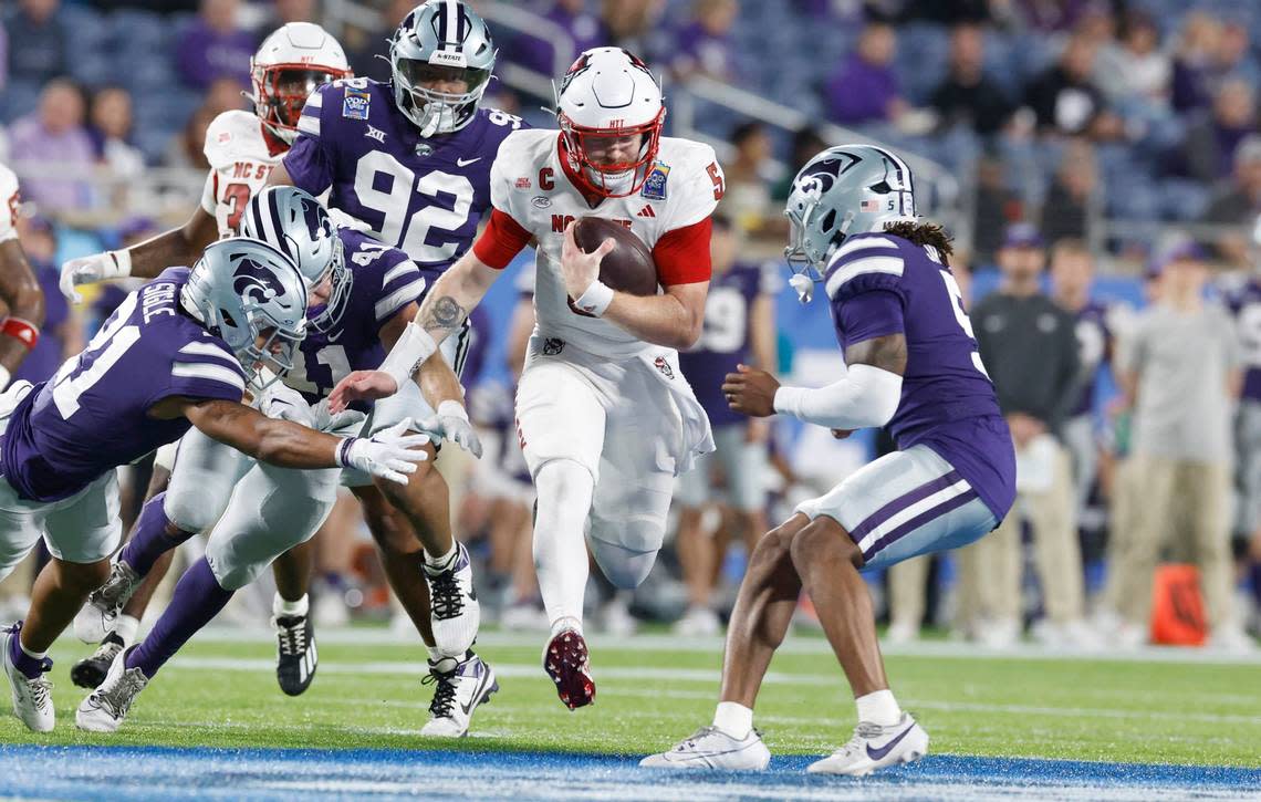 N.C. State quarterback Brennan Armstrong (5) gains yards while pursued by Kansas State defenders during the first half of N.C. State’s game against Kansas State in the Pop-Tarts Bowl at Camping World Stadium in Orlando, Fla., Thursday, Dec. 28, 2023. Ethan Hyman/ehyman@newsobserver.com