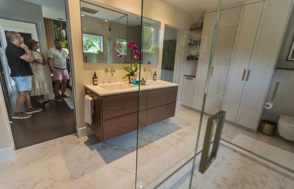 Inside Russ Colombo (far left) and Alain Carrazana’s master bathroom. The bathroom features a walk-in shower, double sink, and custom-designed storage space lining the walls.