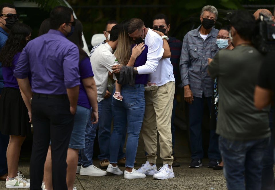 Jose Antonio Rodriguez, center right, is embraced as he arrives at a wake for his 27-year-old-daughter Keishla Rodriguez, whose lifeless body was found in a lagoon Saturday, at a funeral home in San Juan, Puerto Rico, Thursday, May 6, 2021. A federal judge on Monday ordered Puerto Rican boxer Felix Verdejo held without bail after he was charged with the death of Keishla Rodriguez and with intentionally killing the unborn child she was carrying. (AP Photo/Carlos Giusti)