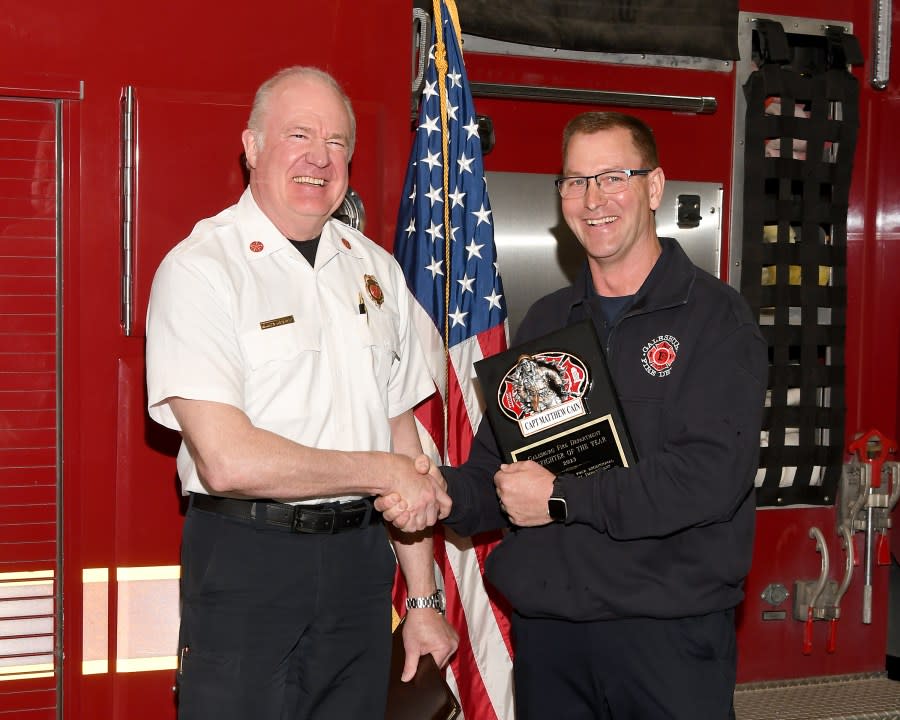 Captain Matthew Cain, right, is congratulated by Galesburg Fire Chief Randy Novind.