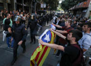 <p>Protestors wave Esteladas (Catalan separatist flags) at a line of Spanish national police who surrounded the leftist Popular Unity Candidacy (CUP) party headquarters in Barcelona, Spain, Sept. 20, 2017. (Photo: Albert Gea/Reuters) </p>