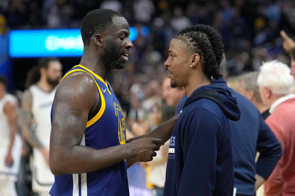 Golden State Warriors forward Draymond Green, left, talks with Memphis Grizzlies' Ja Morant after Game 6 of an NBA basketball Western Conference playoff semifinal in San Francisco, Friday, May 13, 2022. The Warriors won 110-96 and advanced to the conference finals. (AP Photo/Tony Avelar)