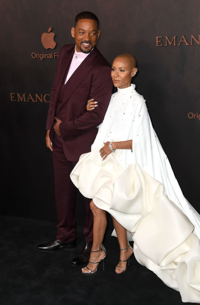 the couple at a premiere, Will in a suit and Jada in a gown with a cape