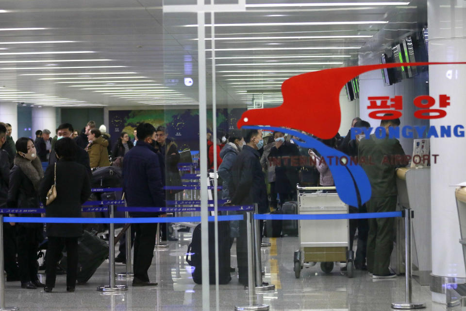 Passengers wearing masks as a precaution against a new coronavirus line up to check in for a flight to Vladivostok, Russia, at the Pyongyang International Airport in Pyongyang, North Korea, Monday, March 9, 2020. (AP Photo/Jon Chol Jin)