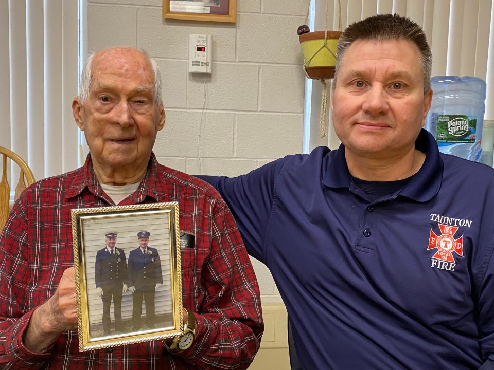 On Tuesday, Jan. 23, 2024, at Taunton's Oakland Fire Station. William Pittsley, left, who served with the Taunton Fire Department from 1965 to 1997, holds up a 1996 photo of himself with his son Michael Pittsley, right, who has has served as a Taunton firefighter since 1996.
