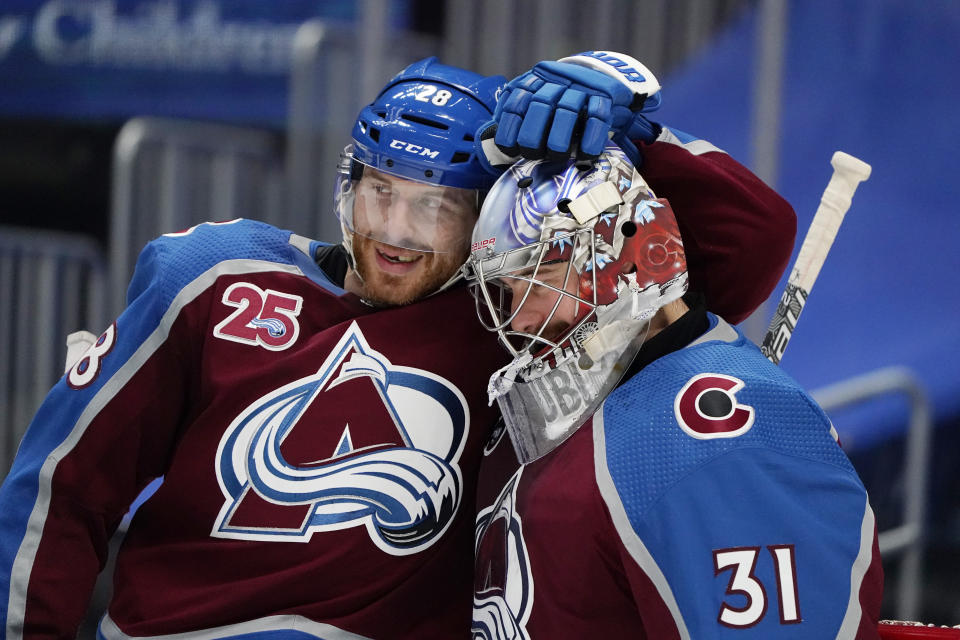 Colorado Avalanche defenseman Ian Cole, left, congratulates goaltender Philipp Grubauer after the team's NHL hockey game against the St. Louis Blues on Friday, Jan. 15, 2021, in Denver. (AP Photo/David Zalubowski)