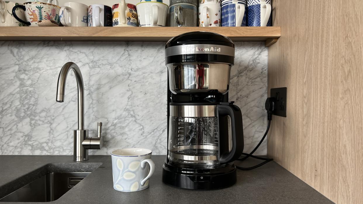  coffee machine on counter with tap and mug 