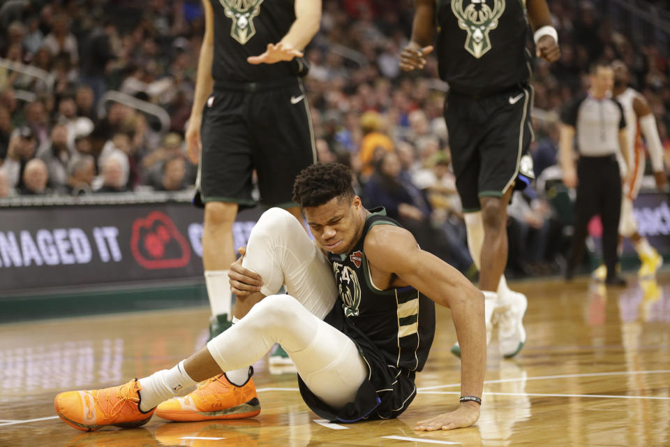 Milwaukee Bucks' Giannis Antetokounmpo grabs his leg during the first half of an NBA basketball game against the Miami Heat, Friday, March 22, 2019, in Milwaukee. (AP Photo/Jeffrey Phelps)